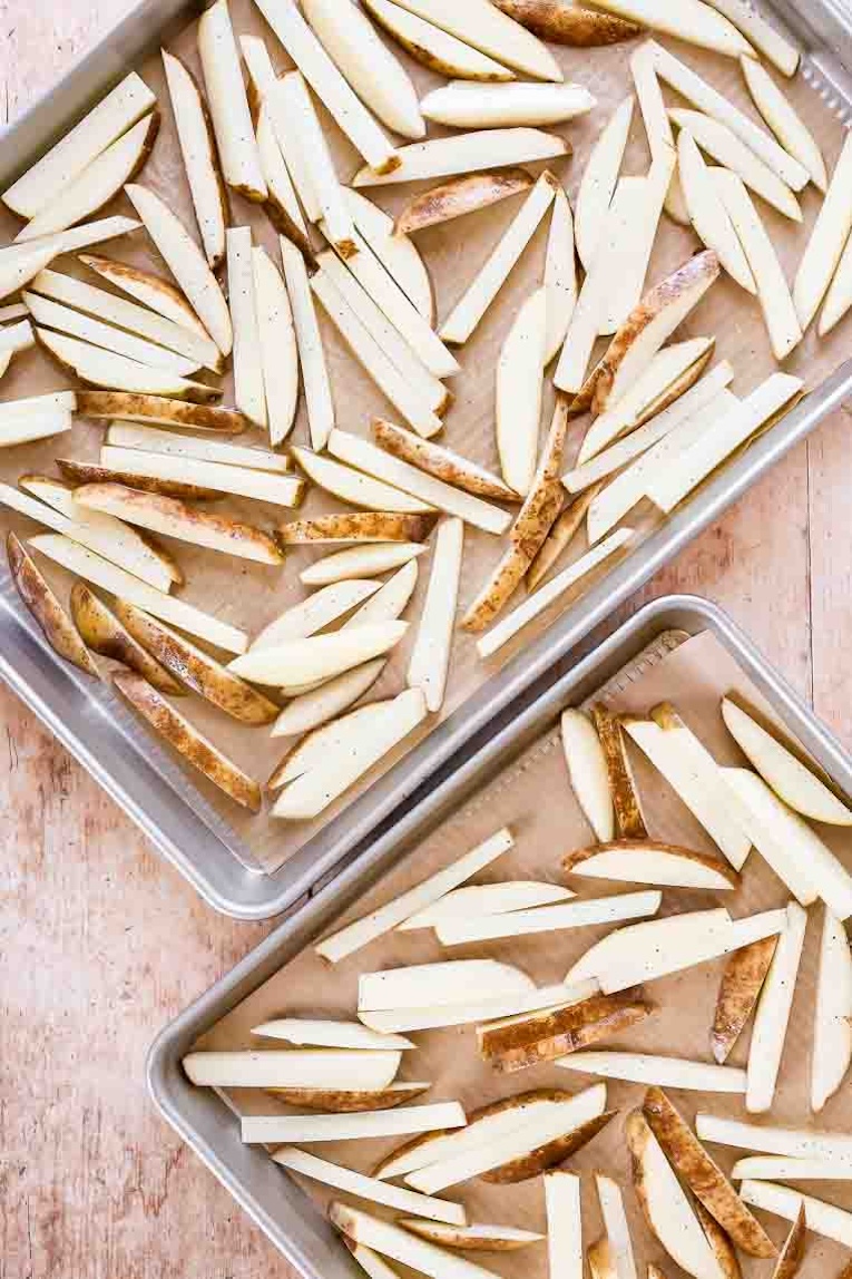 Fries divided on baking sheets with parchment paper.