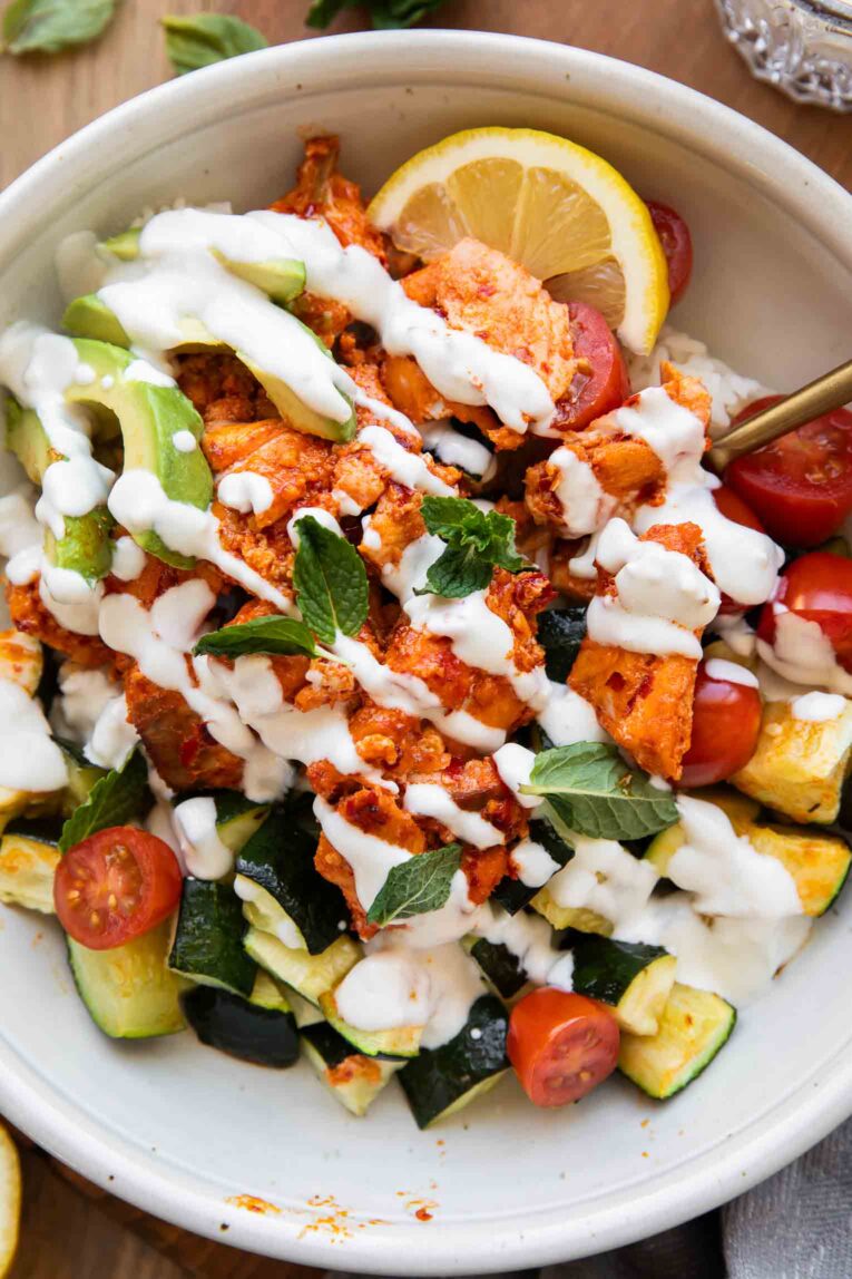 Close up of harissa salmon recipe in a bowl with rice and veggies.