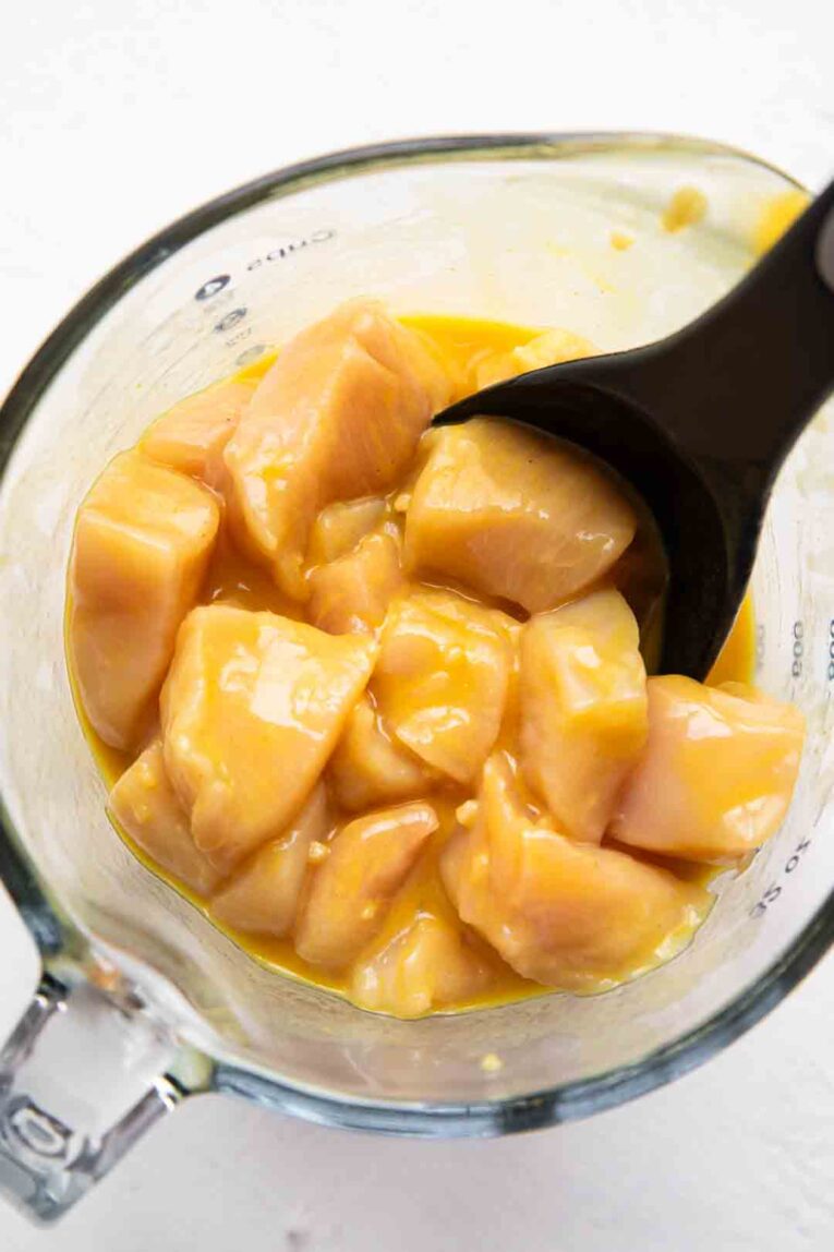 Chicken and honey mustard sauce mixed in a bowl.