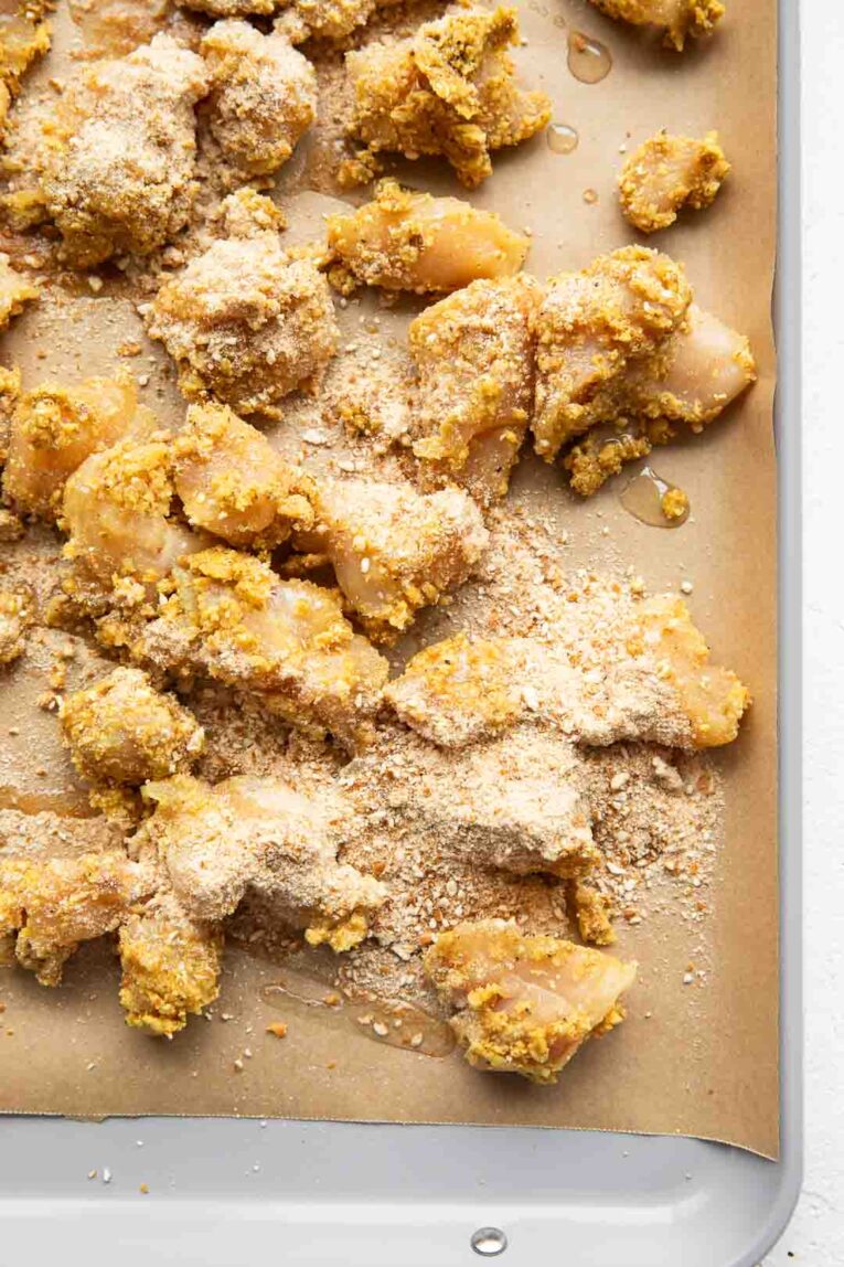 Honey mustard chicken on a baking sheet.