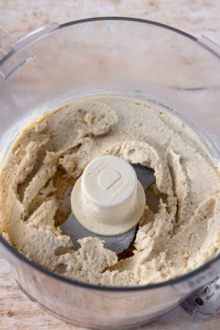 Blended chickpeas and seasoning in a food processor.
