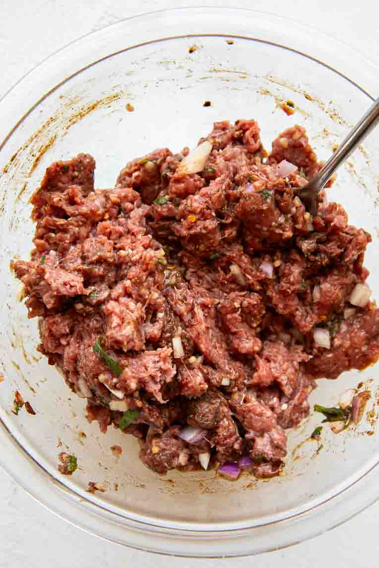 Mixture for Lebanese meatballs in a mixing bowl.