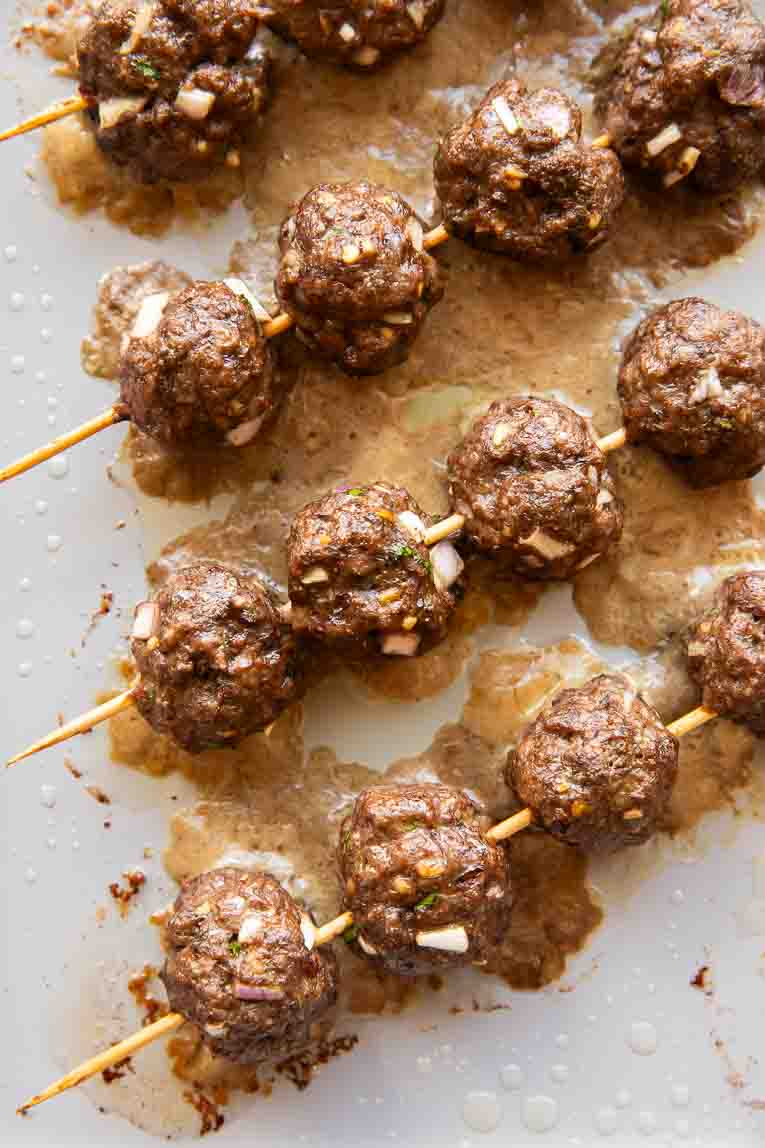 Top photo of Lebanese BBQ meatballs on skewers.