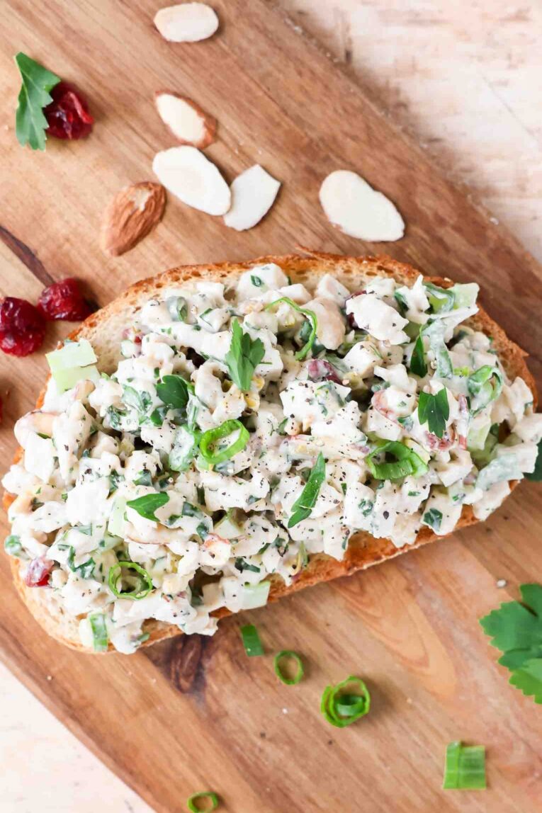 Chicken salad over toasted bread with sliced almonds and cranberries.