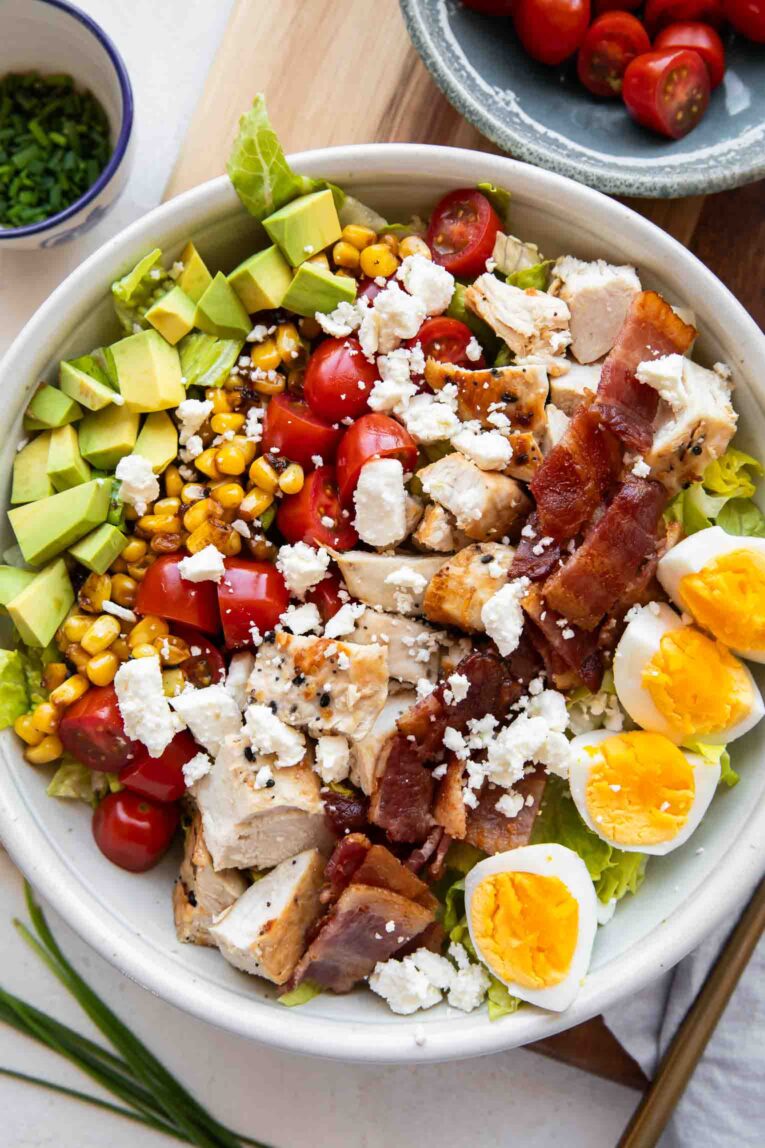 Layers of a cobb salad with grilled chicken.