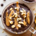 Close up of Snickers Overnight Oats in mug jars.
