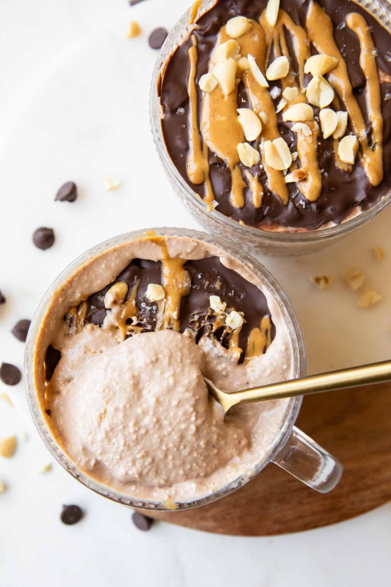 Spoon taking oats out of Snickers Overnight Oats jars.