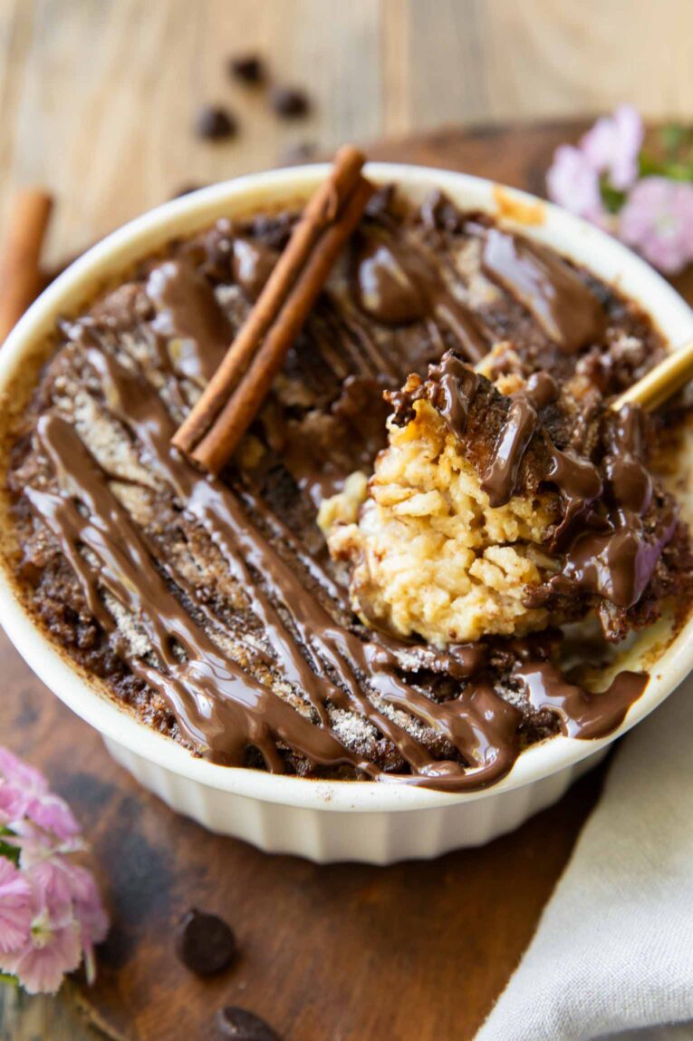 Angled photo of Churro Cheesecake Baked Oats with spoonful taken out.