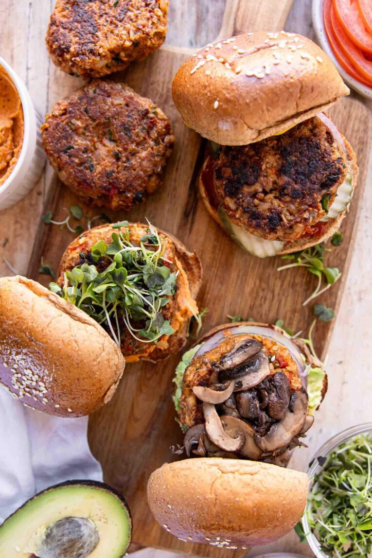 Top photo of Veggie Burgers on a cutting board with toppings.