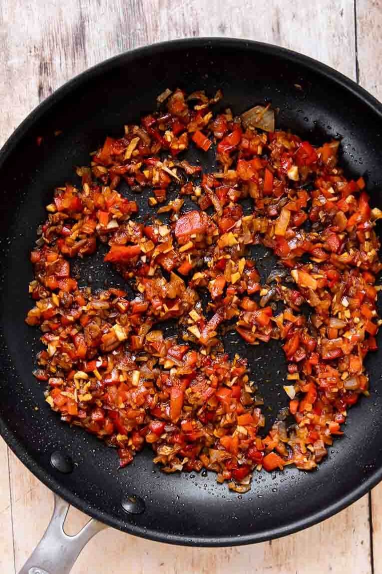 Onions and bell peppers being sautéed.