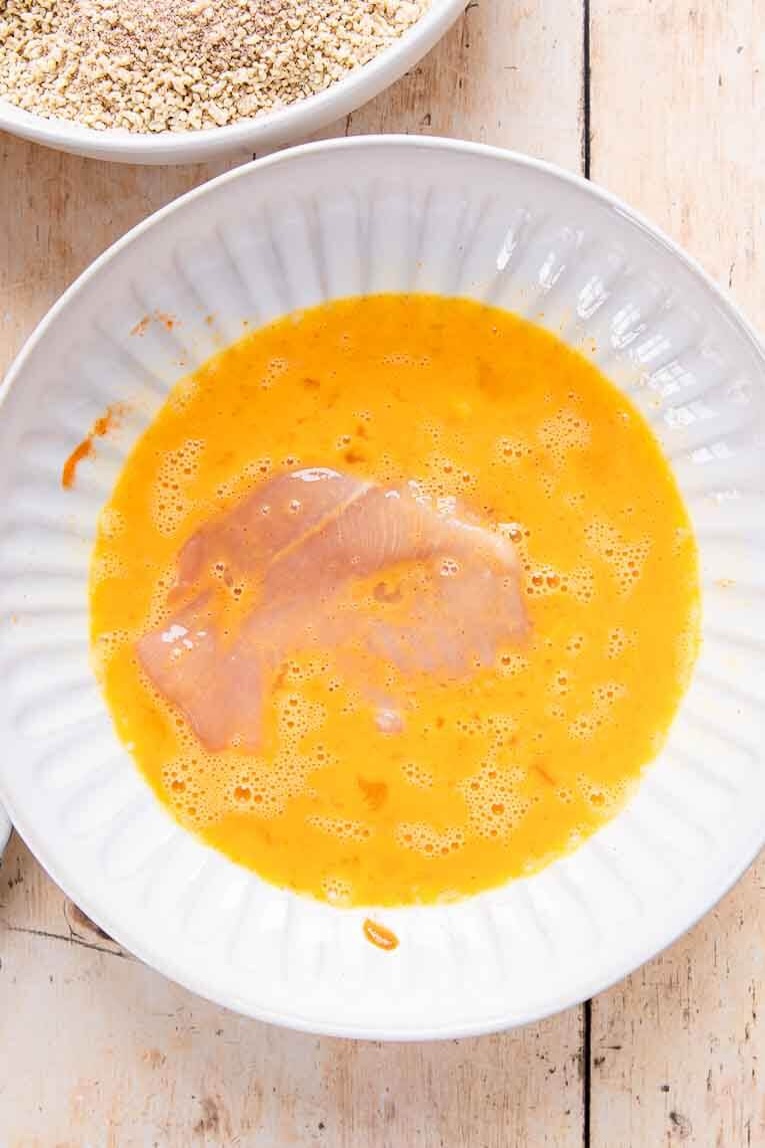 Chicken dipped into egg mixture.