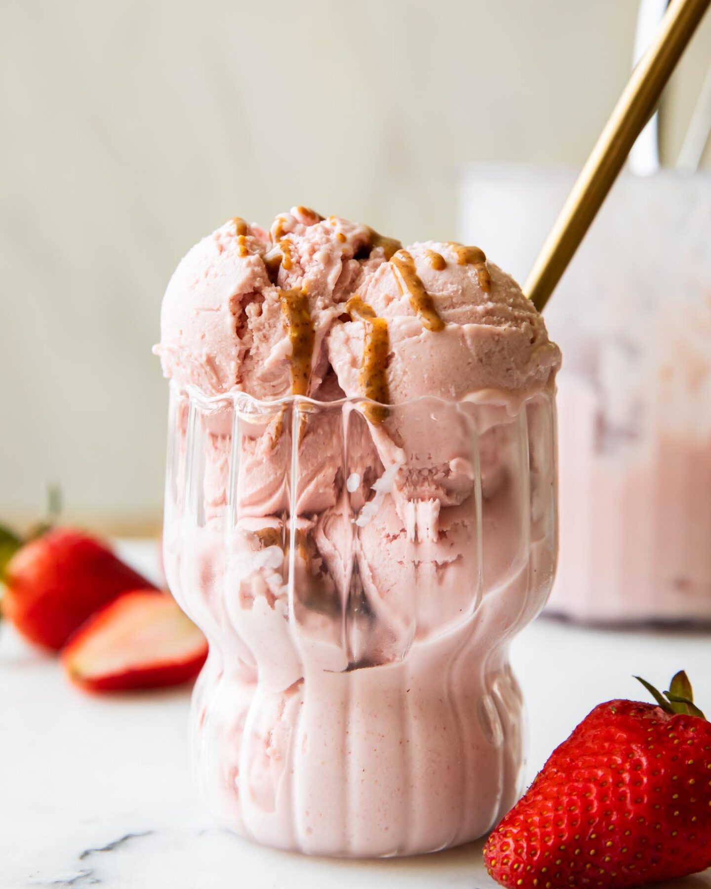 Strawberry Cottage Cheese Ice Cream in a parfait glass with a spoon.