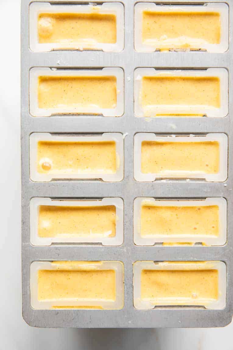 Liquid poured into popsicle mold for peach popsicles.
