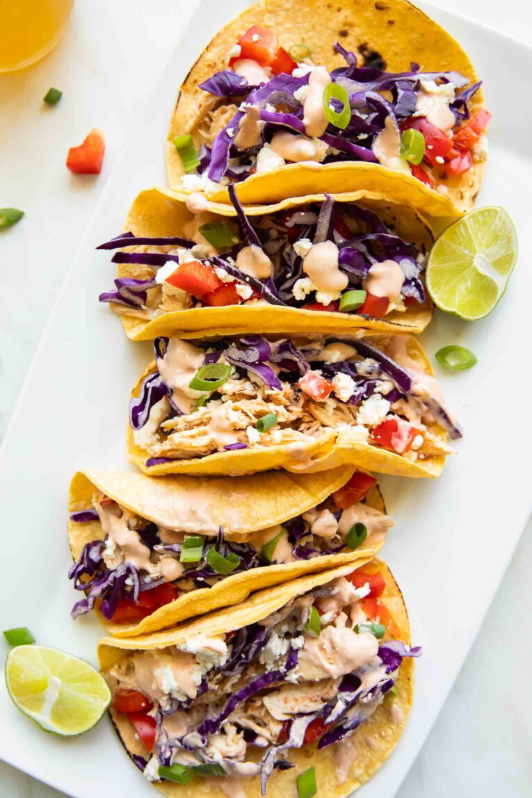Healthy Chicken Tacos with shredded chicken and sriracha sauce on a plate.