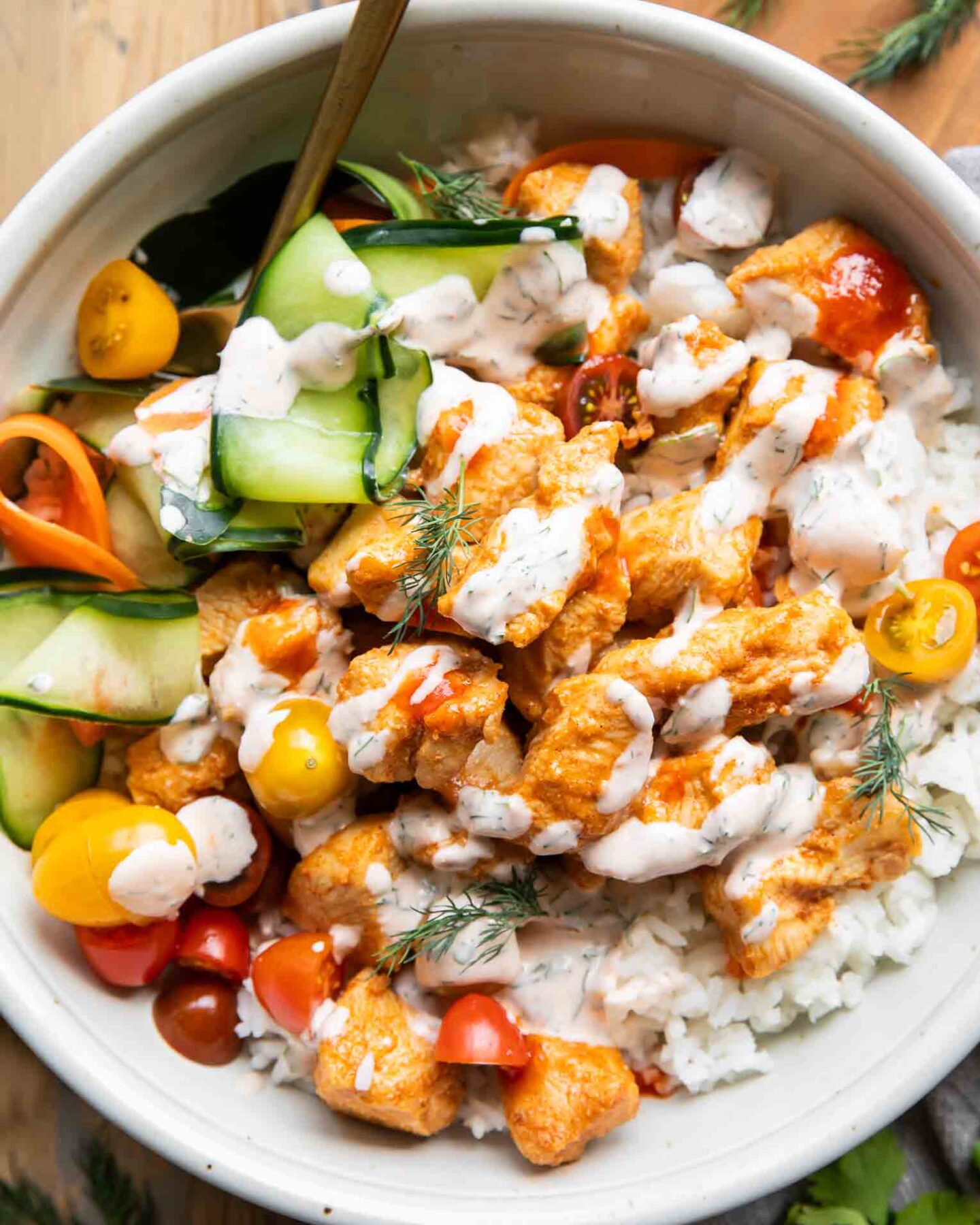 Close up of Sriracha Ranch Chicken in a bowl with rice and pickled veggies.