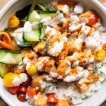 Close up of Sriracha Ranch Chicken in a bowl with rice and pickled veggies.