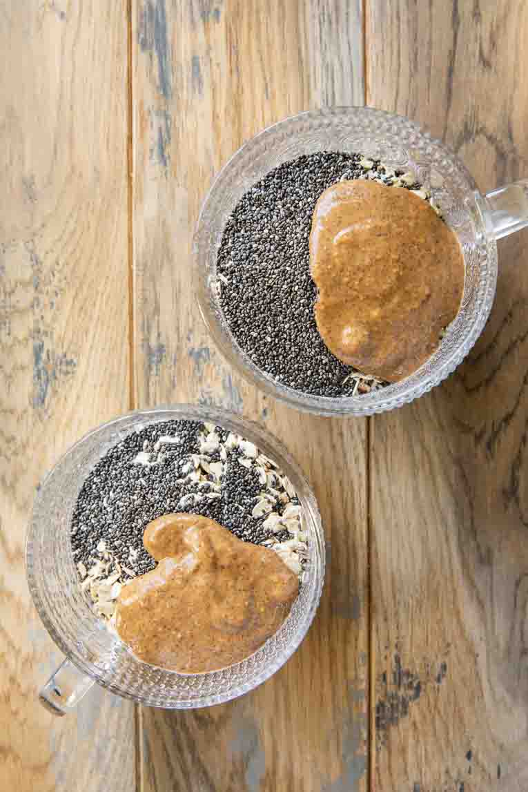 Ingredients for overnight oats in glass mugs.