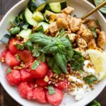 Watermelon Feta Chicken Salad in a bowl with a fork and basil.
