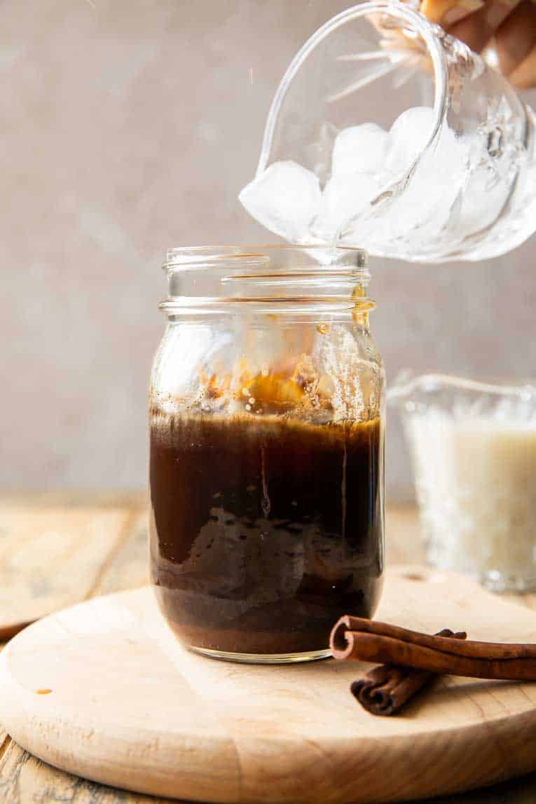 Ice going over espresso in a glass.