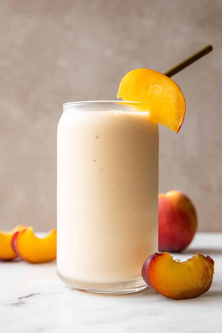 Across photo of peach yogurt smoothie in a glass.