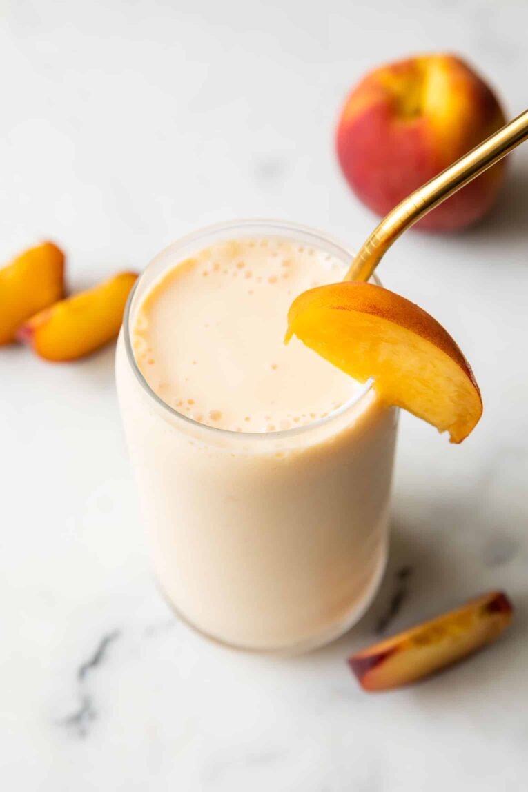 Angled photo of peach smoothie with yogurt.