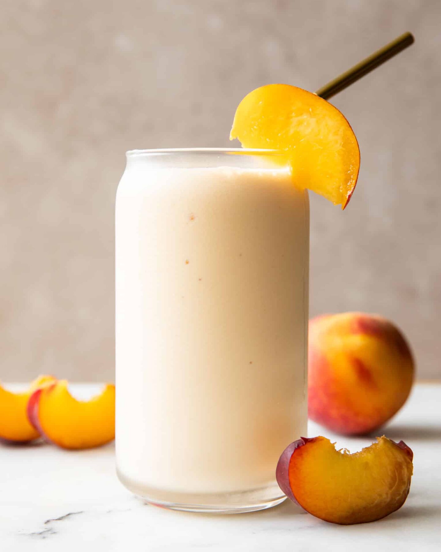 Peach Yogurt Smoothie recipe in a glass with a straw.