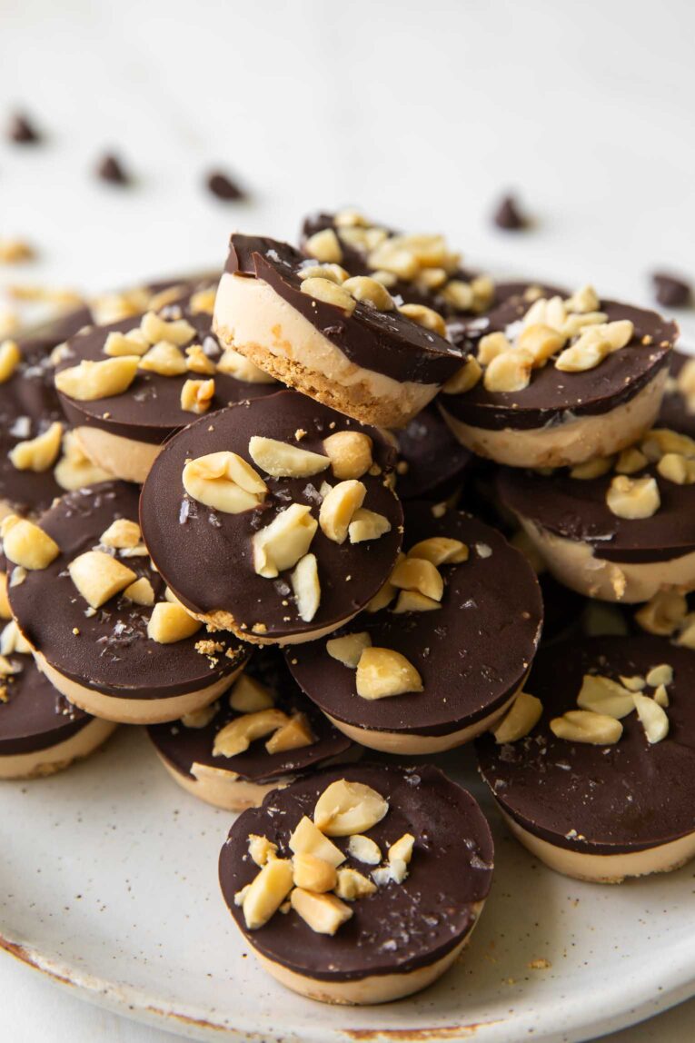 Angled close up of Snickers Protein Bites recipe stacked on a plate.