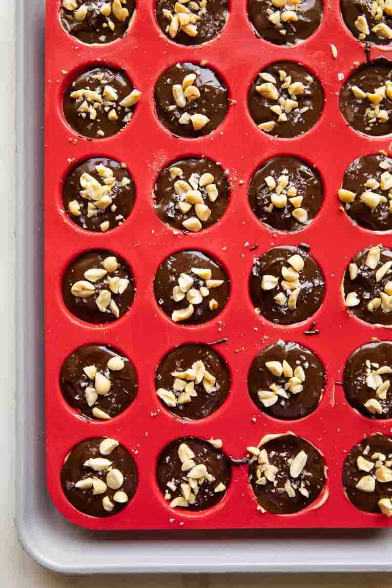 Chocolate topping for Snickers Protein Bites over cheesecake filling.