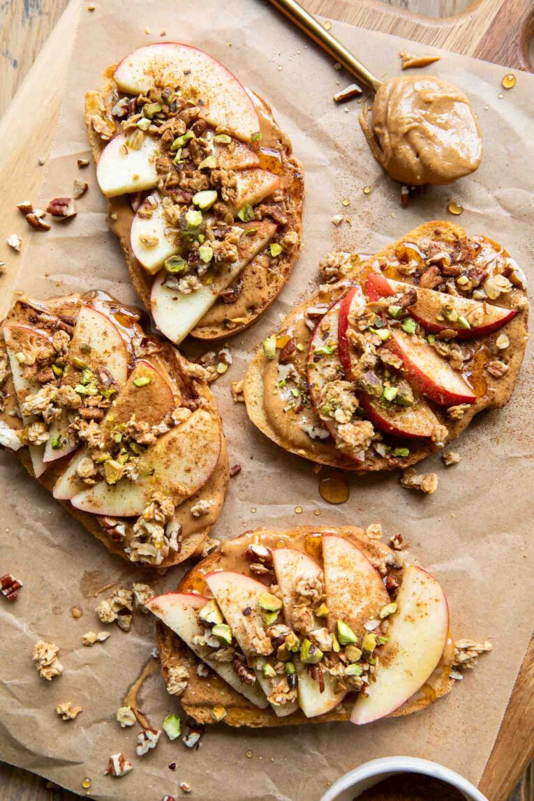 Four apple peanut butter toasts with honey and nuts.