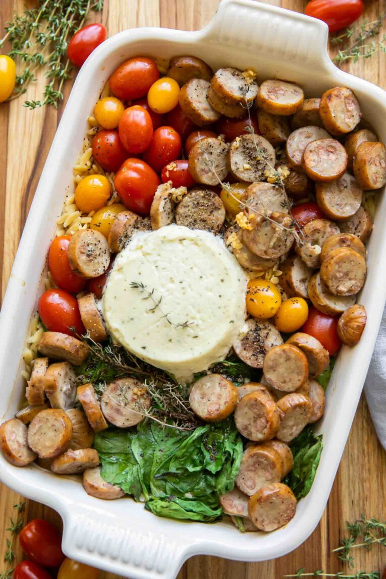 Ingredients for Chicken Sausage Orzo Casserole in a baking dish.