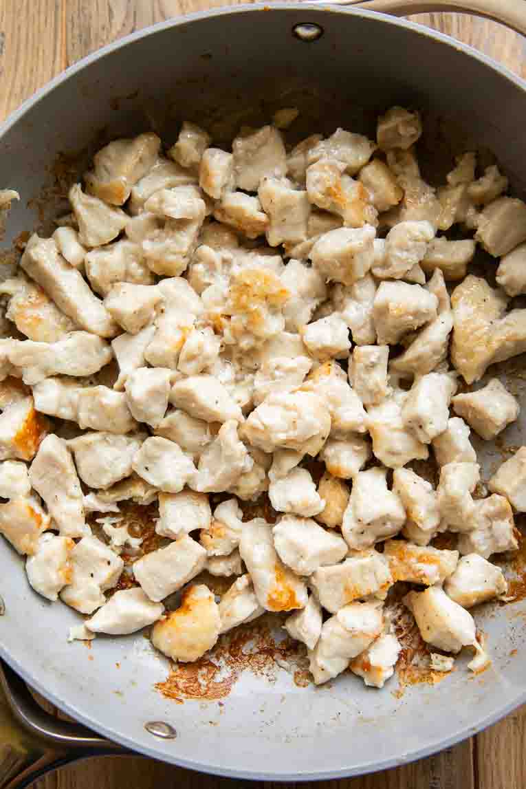Chicken being cooked in skillet.