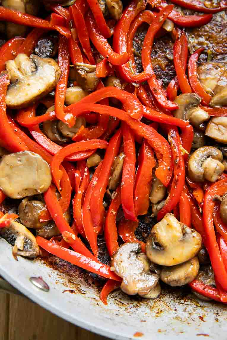 Red Pepper and Mushroom being cooked in skillet.