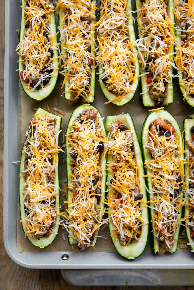 Stuffed zucchini with ground turkey on a baking sheet.