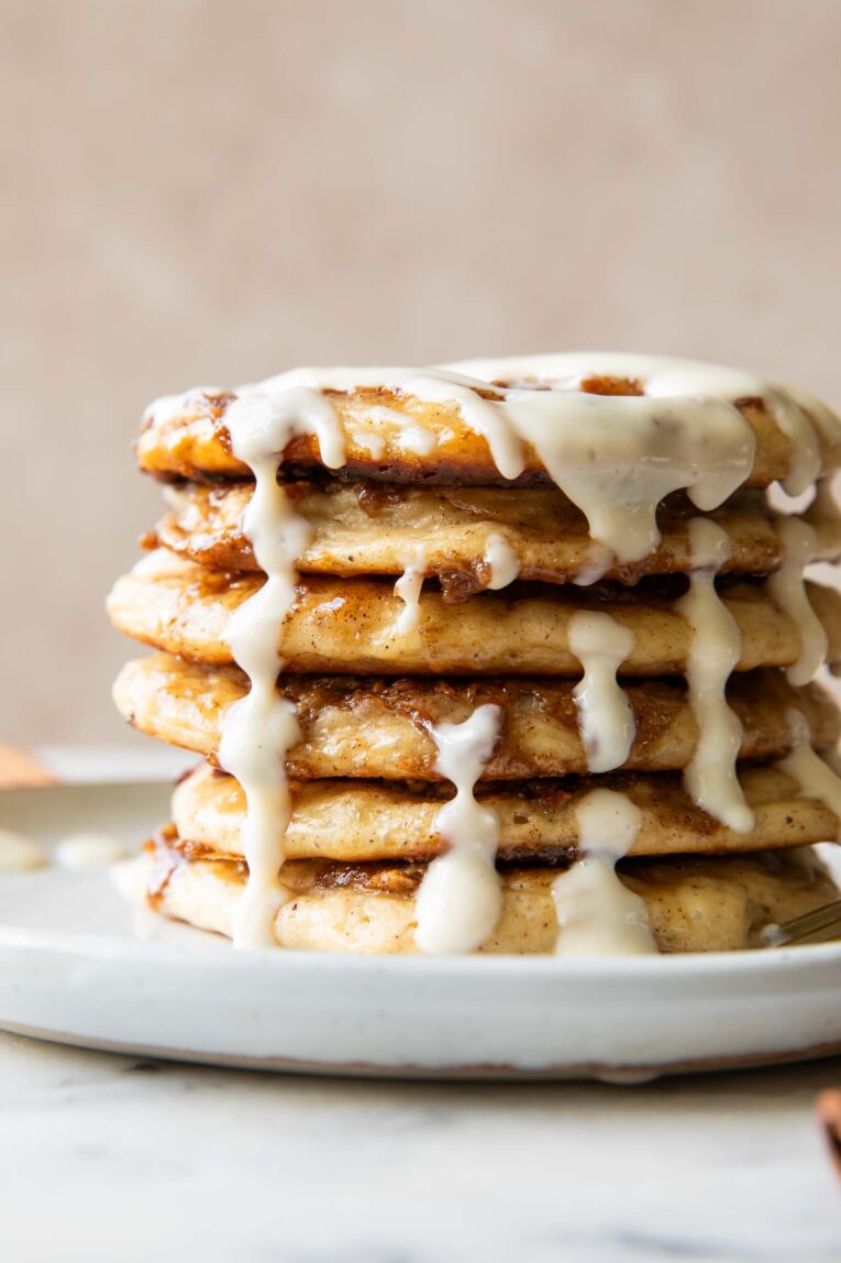 A stack of cinnamon roll pancakes on a plate.
