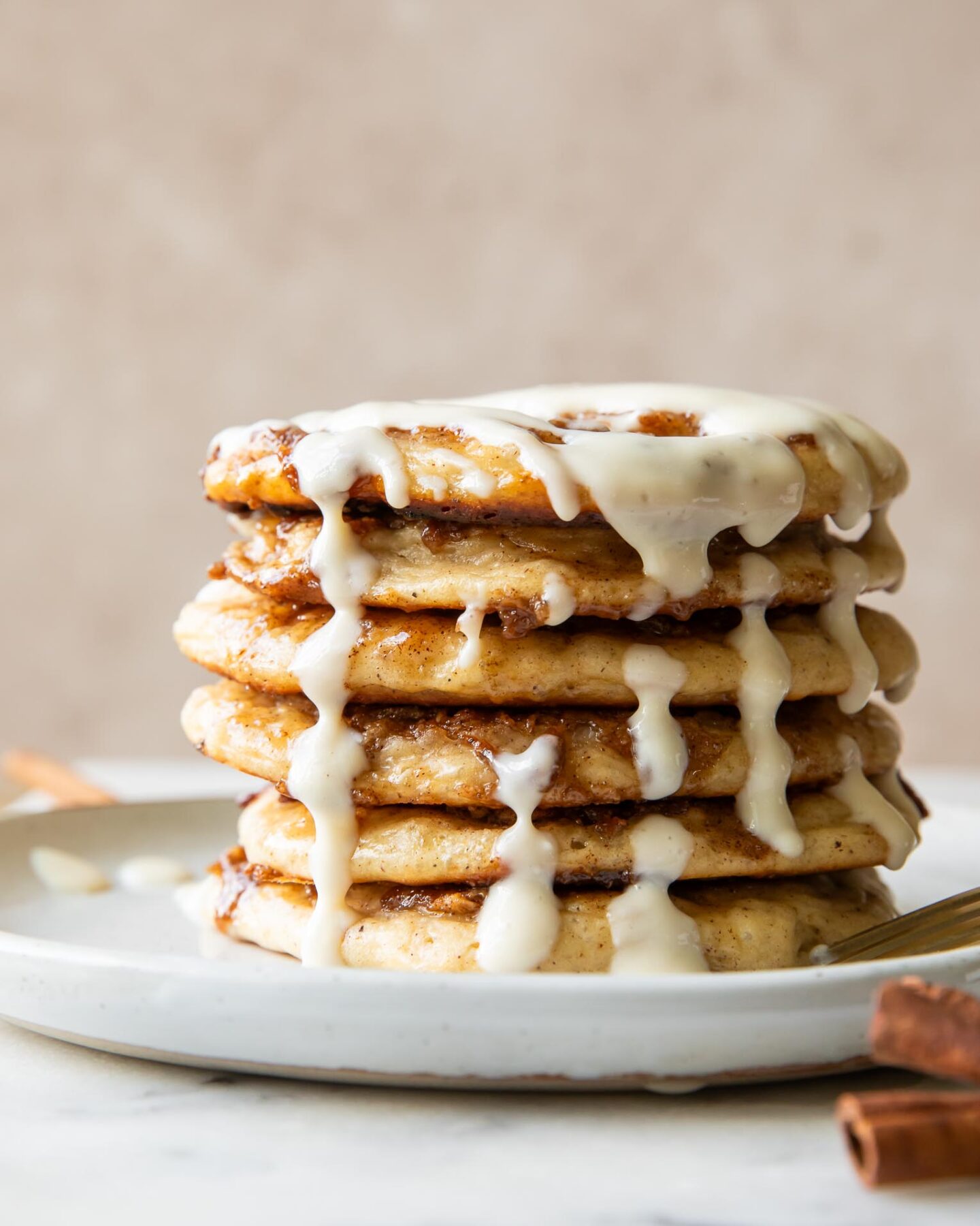 A stack of cinnamon roll pancakes on a plate.