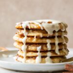A stack of cinnamon roll pancakes on a plate.