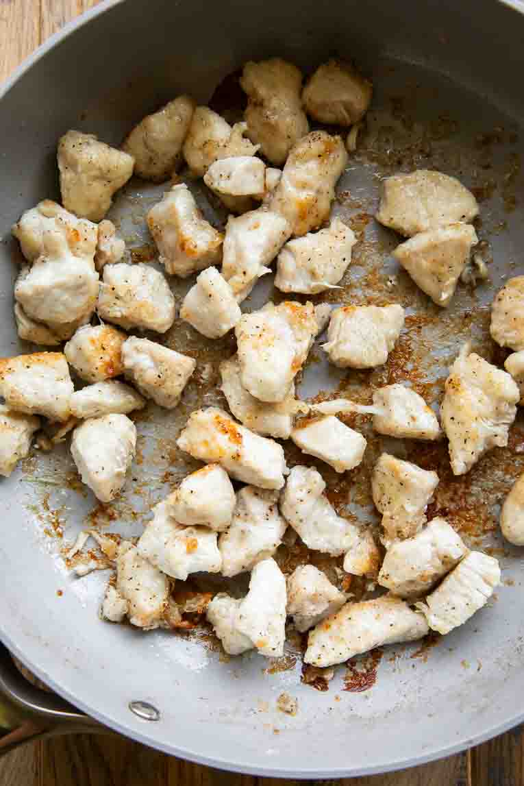Cubed chicken in a skilet.
