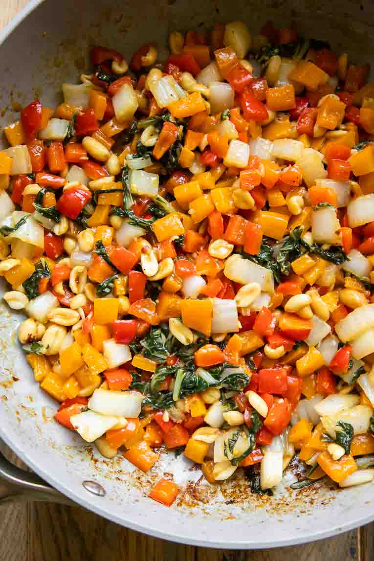 Veggies and chicken in a skillet.