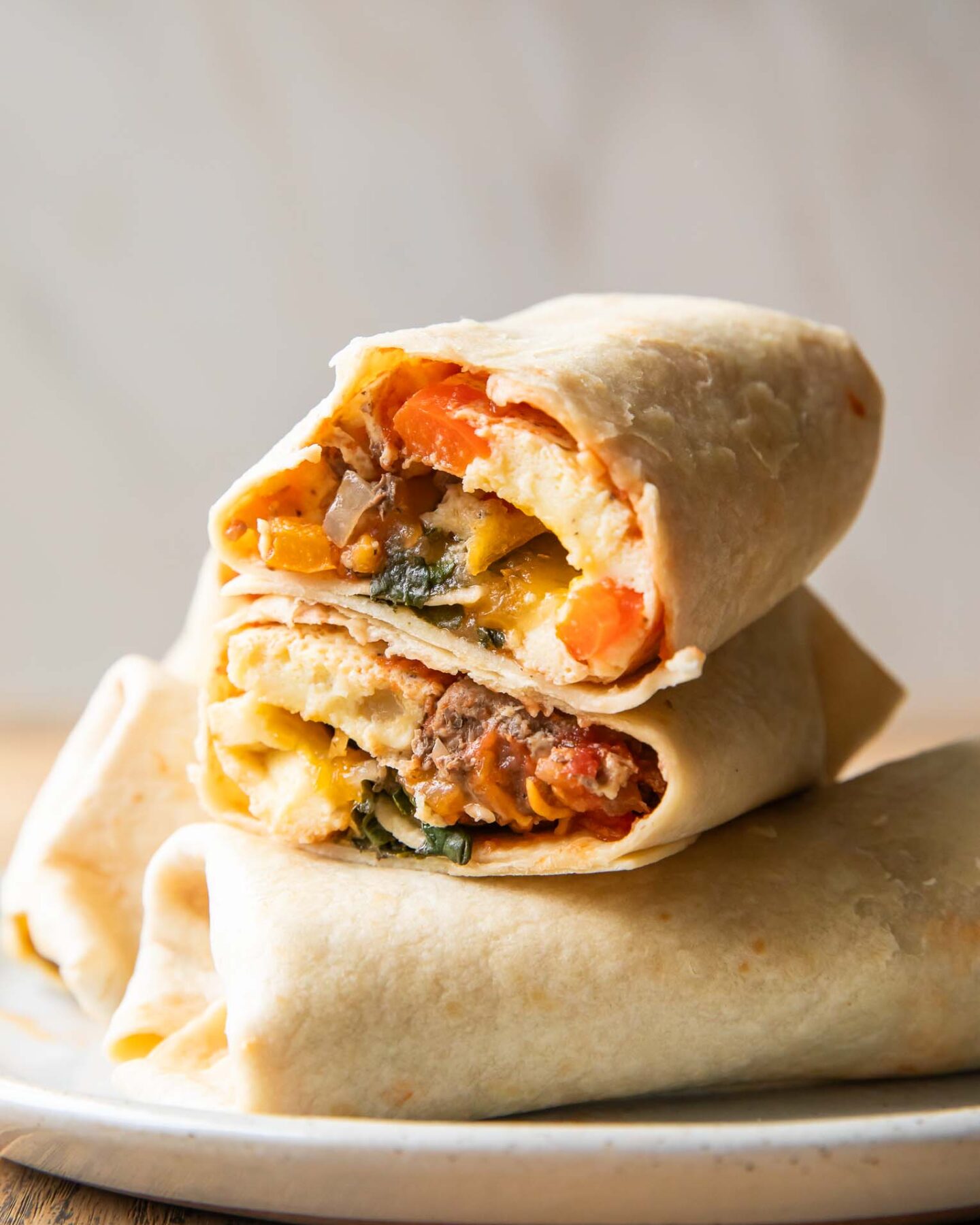 Breakfast Burrito cut in half stacked on top of other burritos.