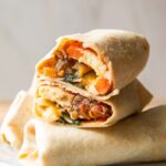Breakfast Burrito cut in half stacked on top of other burritos.