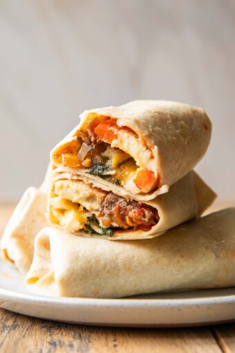 Breakfast Burrito cut in half stacked on top of other burritos.