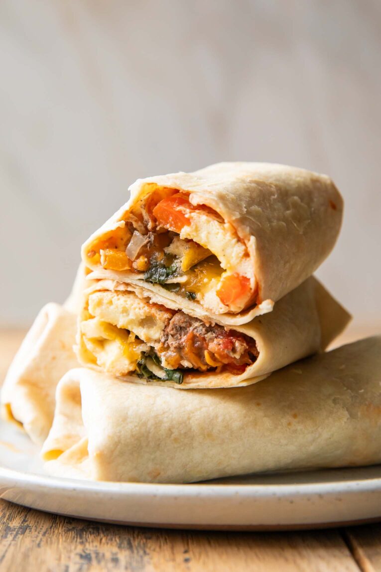 Breakfast Burrito cut in half stacked on top of other burritos.
