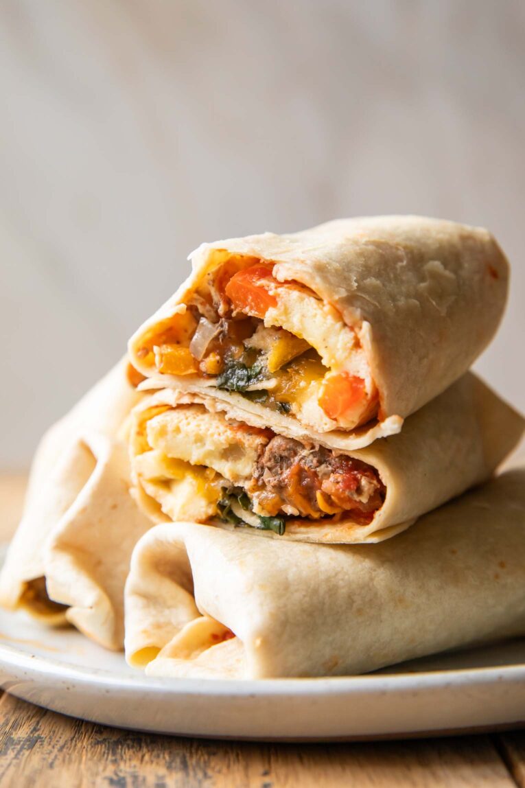 Breakfast Burrito cut in half stacked on top of other burritos.