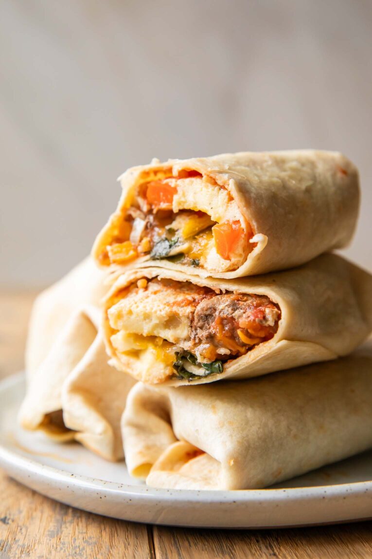 Breakfast Burrito cut in half stacked on top of other burritos.
