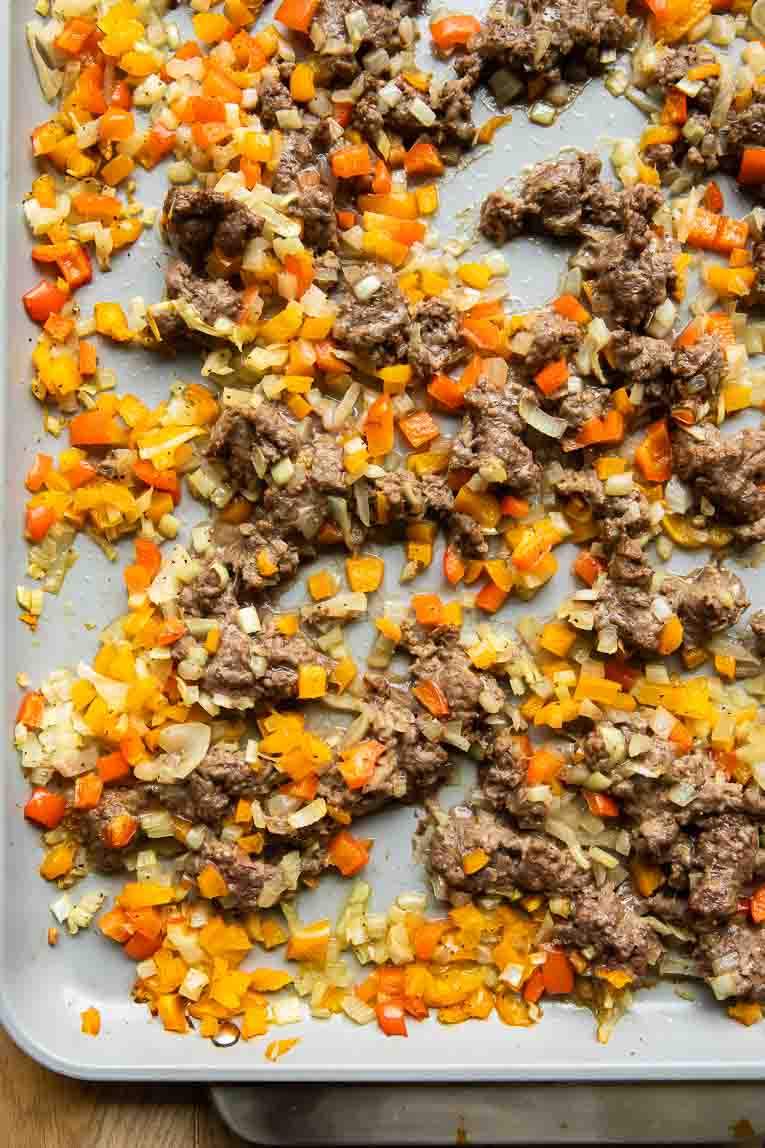Sausage, onions, and peppers on a sheet pan.