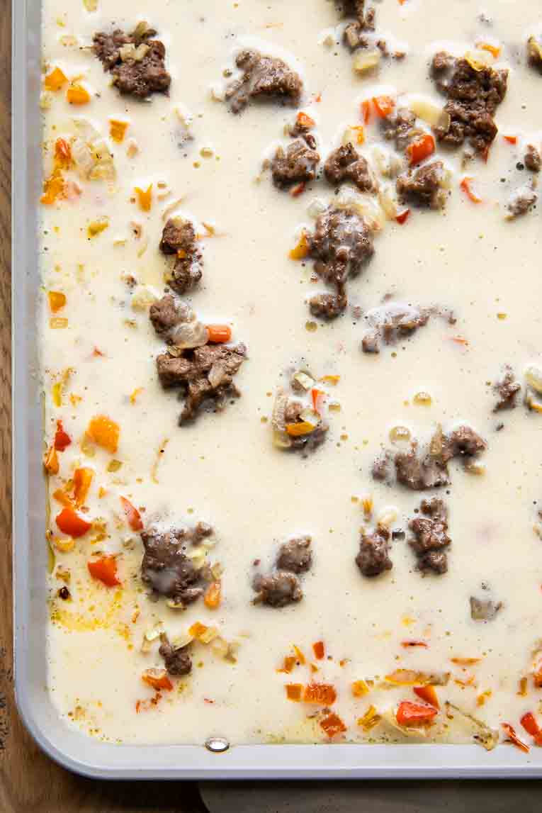 Eggs, sausage, and peppers on a sheet pan.