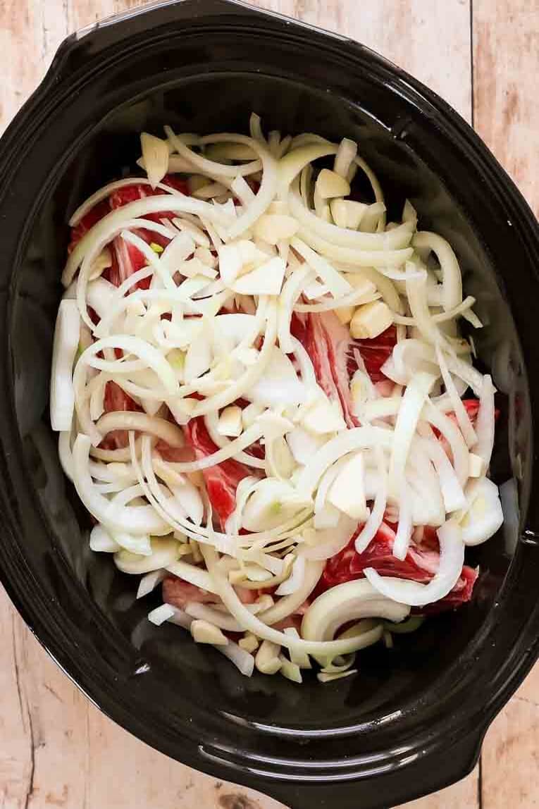Onions and ribs in a crockpot.