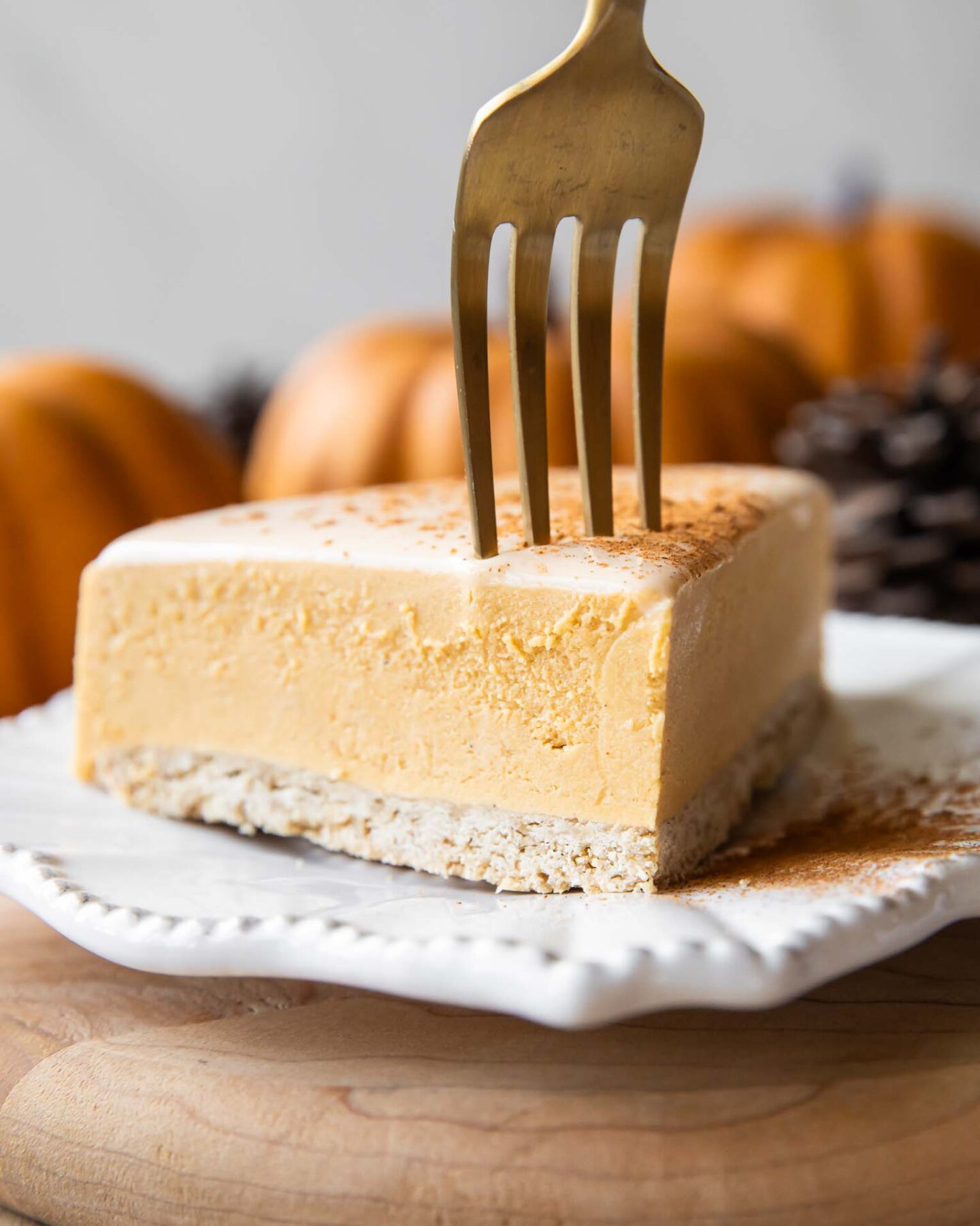 A slice of pumpkin cheesecake with a fork.
