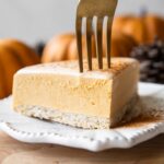 A slice of pumpkin cheesecake with a fork.