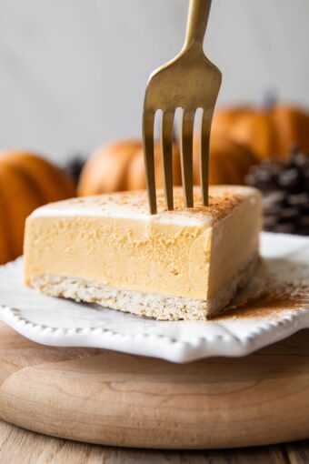 A slice of pumpkin cheesecake with a fork.